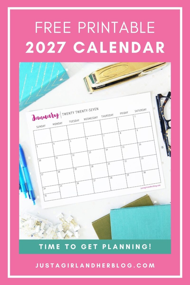 A Free Printable Calendar 2027 page for January sits on a desk surrounded by pens, paper, a stapler, and teal notebooks. The calendar features a pink border with the text: "FREE PRINTABLE 2027 CALENDAR. TIME TO GET PLANNING!"—perfect for organizing your year and getting started with your plans.